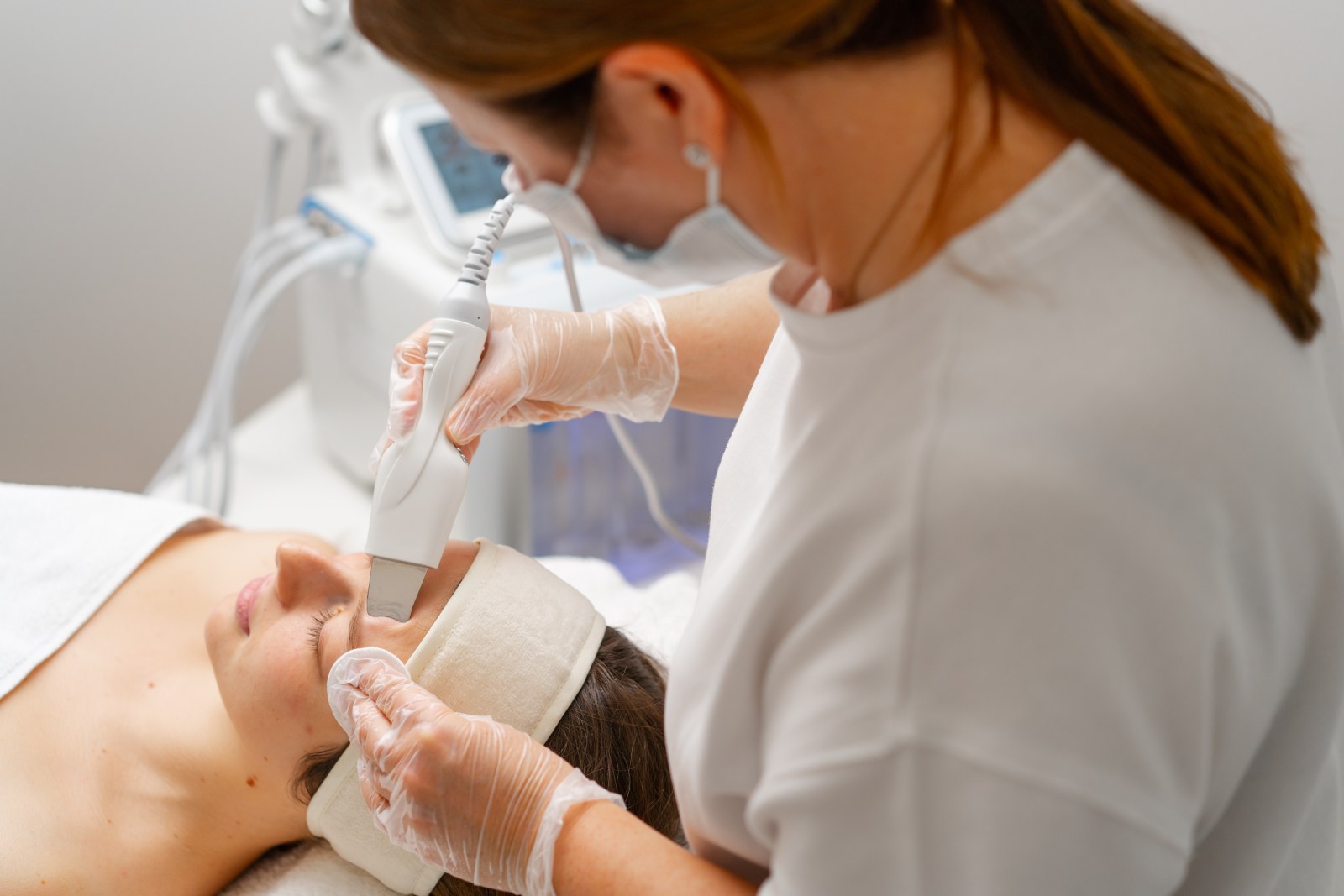 a beautician is cleaning a young woman